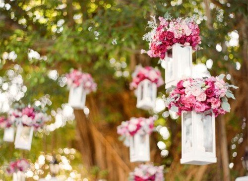 décoration de reception de mariage originale lanternes blanches surpendues garnies de fleurs roses et violettes